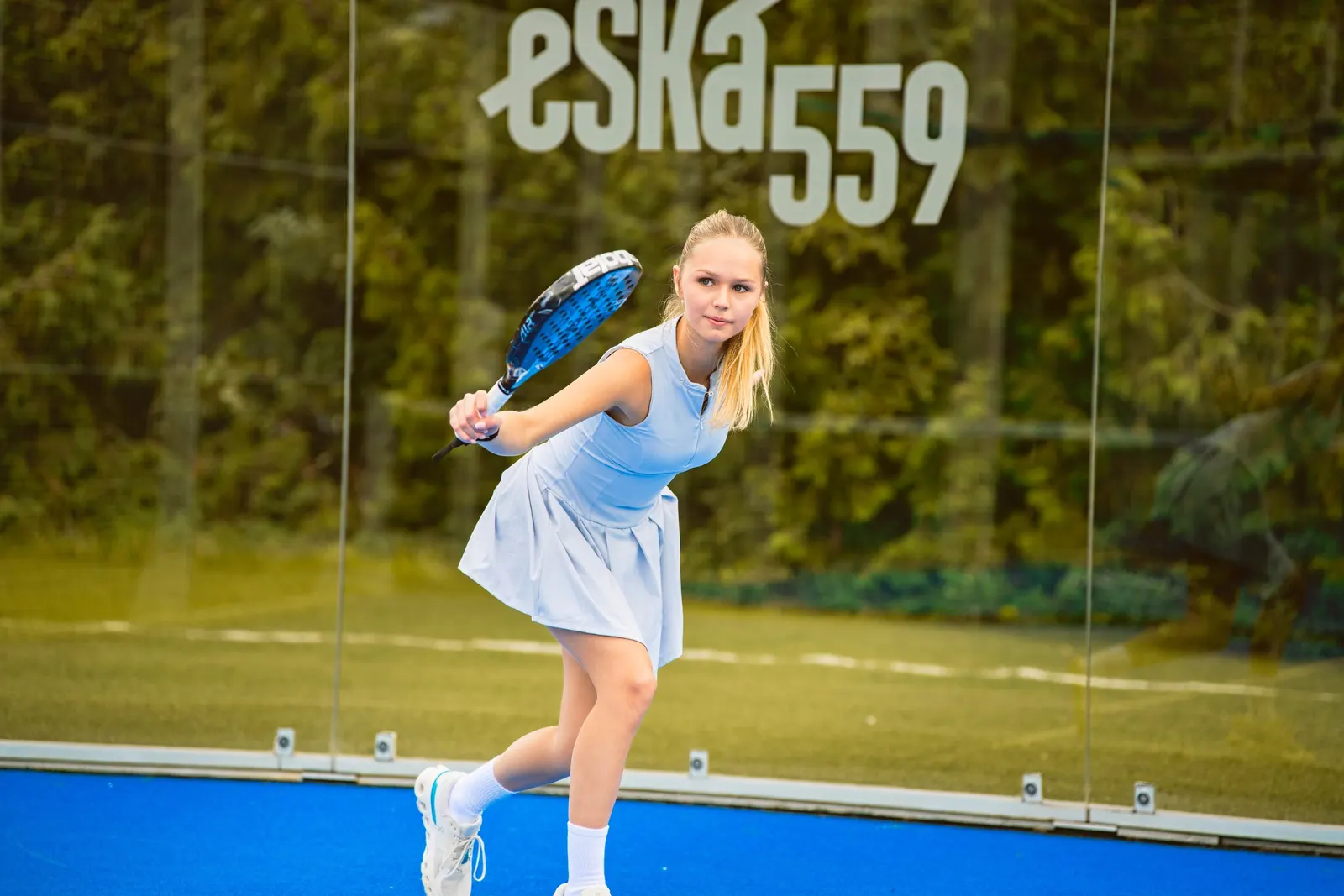 Hráčka padelu při úderu pod logem eSKá 559